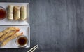 Spring rolls, sweet and sour sauce, shrimp tempura and soybeans on rustic background top view mockup. space for text Royalty Free Stock Photo