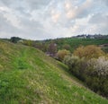 Spring rural hills landscape with terrace fields, farm flowering trees, hilly meadows. Sutkivtsi village, Khmelnytsky region,