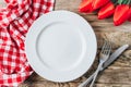 Spring rustic table setting with red tulip, white plate and vintage cutlery on the wooden background Royalty Free Stock Photo