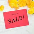 Spring Sale Advertisement with Yellow flowers in a flat layout on gray and white marble.  It`s square with a red card with copy w Royalty Free Stock Photo
