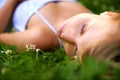 Spring, sleeping and relax with woman on grass in nature for calm, park and peace. Holiday, flowers and field with face Royalty Free Stock Photo