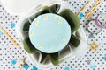 Spring small bento cake with pastel blue icing decorated with cream flowers in a white gift box. Flat lay of birthday cake on the