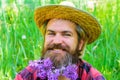 Spring. Smiling Bearded man with flowers in beard. Hipster beard with flowers. Barber shop advertising. Beard style.