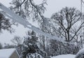 Spring snow covering electric wires attatched to house