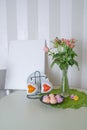 spring still life with a bouquet of roses, cups with hearts, meringues and mockup paintings Royalty Free Stock Photo