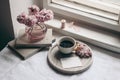 Spring still life composition. Greeting card mockup, marble tray, cup of coffee, old books. Vintage feminine styled