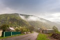 Spring stormy rainy weather. Road and village in green mountain Royalty Free Stock Photo