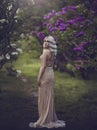 Spring style. Beautiful sensual girl blonde in spring. Blossoming spring garden. Young girl in a gold elegant dress Royalty Free Stock Photo