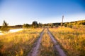 Rural road in green grass field meadow scenery lanscape with blue sky Royalty Free Stock Photo