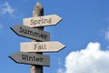 Spring, Summer, Fall, Winter - wooden signpost with four arrows