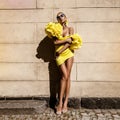 Spring, summer fashion. High fashion model. Glamour, stylish elegant woman. Female model in amazing yellow dress in the city. Royalty Free Stock Photo