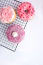 Spring sweets pink donuts with decorations on white background Royalty Free Stock Photo
