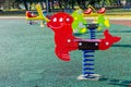 Spring swing in the shape of an animal figure with bright colors in a public children\'s playground Royalty Free Stock Photo