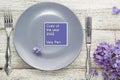 spring table setting with plate fork and knife decorated with lilac flowers in very peri trendy color of the year 2022