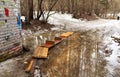 Spring thaw. Wooden bridge over a puddle in the city park. Balashikha, Russia