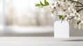 Spring themed image with white blank tag hanging from flowering cherry tree branch over table against blurry background Royalty Free Stock Photo