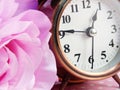 Spring time with alarm clock and artificial flowers bouquet background Royalty Free Stock Photo