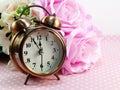 Spring time with alarm clock and artificial flowers bouquet background Royalty Free Stock Photo