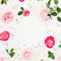 Spring time frame. Floral composition of pastel pink roses flowers and candy confetti on white background. Flat lay, top view Royalty Free Stock Photo