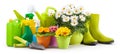 Spring time, pots colorful primroses and daisies, green boots and watering can. Gardening tools, trowel, spray bottles of