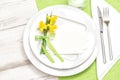 Spring table decoration narcissus flowers White plate fork knife Royalty Free Stock Photo