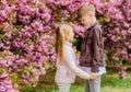 Spring time to fall in love. Kids in love pink cherry blossom. Love is in the air. Couple adorable lovely kids walk