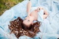 Spring touch. Happy beautiful young smiling woman in blue dress enjoy fresh flowers and sun light in blossom park at