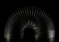 Spring toy slinky on black Royalty Free Stock Photo