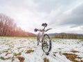 Spring trip with steep mountain bike in snowy landscape. White mtb