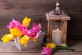 Spring tulips in box and candle in lantern on vintage backgro Royalty Free Stock Photo