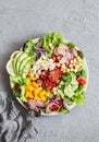 Spring vegetable buddha bowl. Salad with veggies, chickpeas, avocado and feta. Delicious healthy food. On a gray background Royalty Free Stock Photo