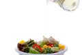 Spring vegetable salat with tomatoes onion cheese and olives. olive oil pouring into bowl of salat.