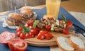 Spring vegetables - bell peppers, cucumbers, onions, lettuce, tomato with grilled kebabs and orange juiceon a blue tablecloth Royalty Free Stock Photo