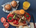 Spring vegetables - bell peppers, cucumbers, onions, lettuce, tomato with grilled kebabs and orange juiceon a blue tablecloth Royalty Free Stock Photo