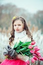 Spring vertical portrait of romantic child girl with tulips bouquet on the walk