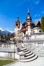 Spring view of Peles Castle with snow Bucegi Mountains in the background. Royalty Free Stock Photo