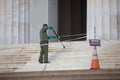 A cleaning company employee washes the steps of the Lincoln Memorial with water