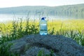 Spring water bottle with wile lake background Royalty Free Stock Photo