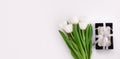 Spring website header template. White tulip black gift box with silver ribbon on light background flat lay. Copy space Royalty Free Stock Photo