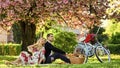 Spring weekend. Romantic picnic with wine. Give uncommon, unique gifts spontaneously. Happy loving couple relaxing in Royalty Free Stock Photo