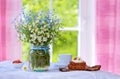 Spring wild flowers bouquet and breakfast on the table. Royalty Free Stock Photo
