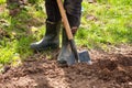 Male Farmer In Rubber Boots With Shovel And Potatoes In Ground I
