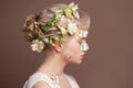 Spring young beautiful woman concept. Blonde female model with spring flowers in her healthy hair and butterfly on her clear skin Royalty Free Stock Photo