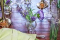 Springtime - Pale lime linen napkin and a variety of vases sit on a wooden table in shades of purple and green - close-up and