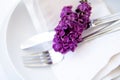 Springtime table setting with lilac branch on white linen napkin Royalty Free Stock Photo