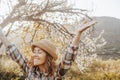 Springtime. Welcome spring concept image with overjoyed happy woman raising arms and closing eyes hugging and loving nature around