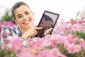 Springtime, woman with tablet smiling in garden