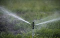 Sprinker irrigation system spraying water on field Royalty Free Stock Photo