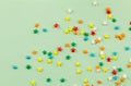 Sprinkle background with bright colourful star sprinkles scattered on pale green background with space for text - top view photo