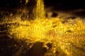 Sprinkle glitter gold dust in the dark textured abstract background elegant Royalty Free Stock Photo